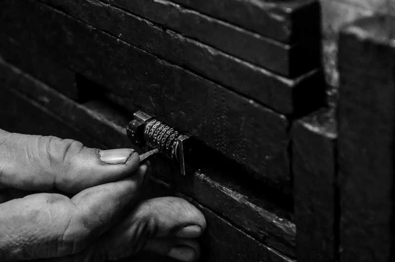 A hand trying to pick a numerical lock with a toothpick